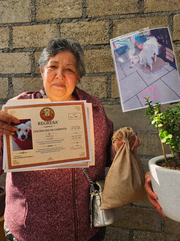 Una señora sostiene el certificado de Lala junto a su planta y su costalito